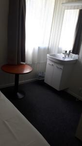 a bathroom with a sink and a table and a window at Lunde Turiststasjon in Skei