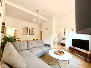 ein Wohnzimmer mit einem Sofa und einem TV in der Unterkunft Villa Cuchema in Cochem