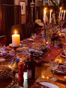 - une table à manger avec une bougie et des assiettes de nourriture dans l'établissement Evermoore Retreat Castle by the river, à Gleniffer