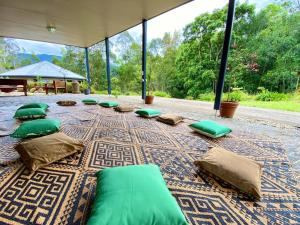 Habitación grande con almohadas verdes en una alfombra. en Evermoore Retreat Castle by the river, en Gleniffer