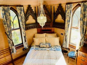 um quarto com uma cama num quarto com janelas em Evermoore Retreat Castle by the river em Gleniffer
