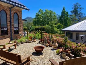 un giardino con panchine e piante in vaso di fronte a un edificio di Evermoore Retreat Castle by the river a Gleniffer