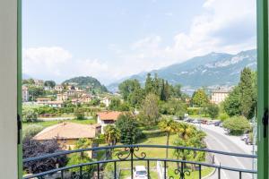 uma vista a partir de uma varanda de uma cidade com montanhas em Green House Regatola by Wonderful Italy em Bellagio