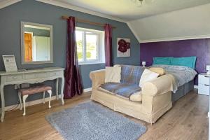 a bedroom with a bed and a couch and a mirror at Maesyfelin Isaf B&B in Llanybydder