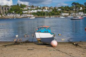 un barco sentado en la orilla de un cuerpo de agua en Finest Retreats - Brunels Reach, en Saltash