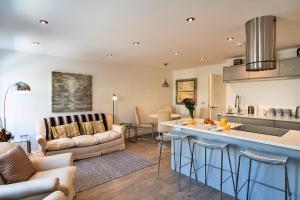 Finest Retreats - Brunels Reach في سالتاش: مطبخ وغرفة معيشة مع أريكة وطاولة
