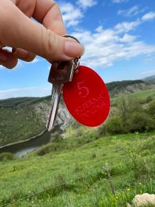 een persoon met een bos sleutels in een veld bij Biserna Dolina Uvac in Sjenica