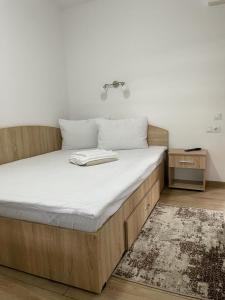 Bett in einem Zimmer mit einer weißen Matratze in der Unterkunft Casa Milla in Sovata