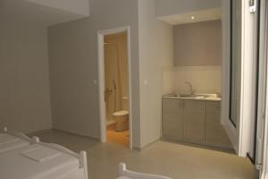 a white bathroom with a toilet and a sink at Evgenios Studios in Kavos