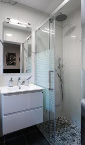 een badkamer met een wastafel en een glazen douche bij Villa Paro in Pag