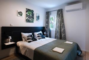 een slaapkamer met een bed met 2 kussens en een raam bij Villa Paro in Pag