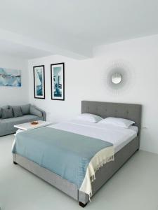 a bedroom with a large bed and a couch at Iliada Studio Oxygen Neptun in Neptun