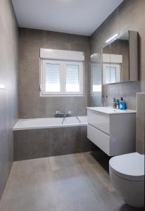 een badkamer met een bad, een toilet en een wastafel bij Villa Paro in Pag