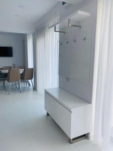 Vestidor blanco en una habitación blanca con mesa en Iliada Studio Oxygen Neptun, en Neptun