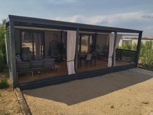 eine abgeschirmte Veranda mit einem Sofa und Stühlen in der Unterkunft Luxury mobile home LA ISLA BONITA, Terra Park SpiritoS in Kolan