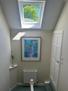 a attic room with a skylight and a painting on the wall at Luxury Garden Cottage in Dalry