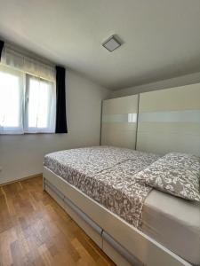 een slaapkamer met een bed en 2 ramen bij Apartments Ursula 3 in Trogir