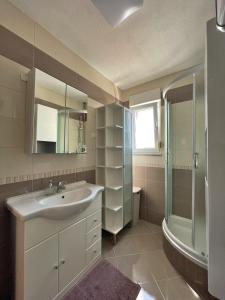 een badkamer met een wastafel en een douche bij Apartments Ursula 3 in Trogir