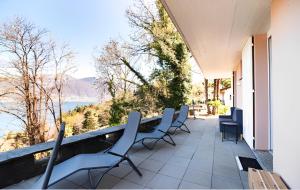 Gambarogno的住宿－Casa AmaRe - einzeln stehendes Haus mit spektakulärer Aussicht，阳台配有椅子,享有水景