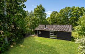 een klein zwart huis met een tuin bij Cozy Home In Give With Kitchen in Give