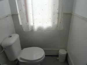a bathroom with a white toilet and a window at Hotel Entreolivos in El Pedroso