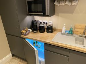 eine Küchentheke mit einer Spüle und einer Mikrowelle in der Unterkunft The View, Luxury studio in Curbar