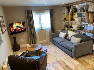 a living room with a couch and a table at The View, Luxury studio in Curbar