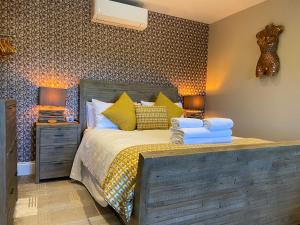 a bedroom with a bed with two night stands and two lamps at The View, Luxury studio in Curbar