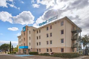 un hotel con un cartel en la parte superior en Kyriad Direct Mont De Marsan - St Avit, en Saint-Avit