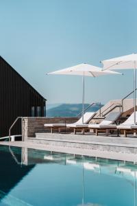 a swimming pool with chairs and an umbrella at Jaglhof in Gamlitz