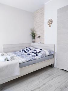 ヤスタルニャにあるPokoje u Rybakaの白いベッドルーム(ベッド1台付)