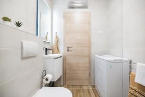 een witte badkamer met een toilet en een wastafel bij Bridge Comfort Apartment in Zadar