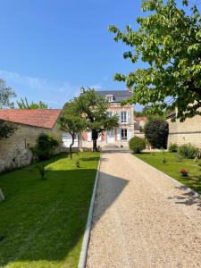 a driveway in front of a large house at La Maison du Pere Pilon avec petit dejeuner in Auvers-sur-Oise