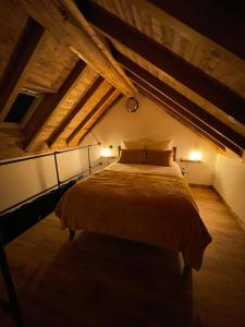 ein Schlafzimmer mit einem großen Bett im Dachgeschoss in der Unterkunft La Maison du Pere Pilon avec petit dejeuner in Auvers-sur-Oise