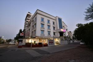 a large white building on a city street at Click White House Residency, Vadodara in Vadodara