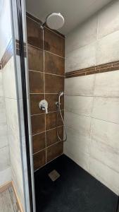 La salle de bains est pourvue d'une douche avec une porte en verre. dans l'établissement Logis Hôtel Restaurant Bellevue, à Saint-Martin-dʼArdèche
