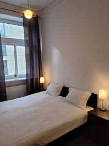 una camera da letto con un grande letto bianco con due lampade di Rent-Apart City Center - apartament z 1 sypialnią a Łódź