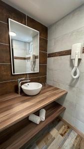 La salle de bains est pourvue d'un lavabo et d'un miroir. dans l'établissement Logis Hôtel Restaurant Bellevue, à Saint-Martin-dʼArdèche