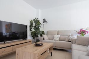 uma sala de estar com um sofá e uma televisão em torderalux em Tordera