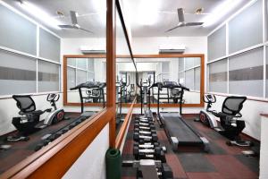 einen Fitnessraum mit Laufbändern und Crosstrainern in der Unterkunft Click White House Residency, Vadodara in Vadodara