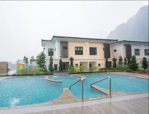 a large swimming pool in front of a building at Onsen Oasis Premium Suites in Tambun