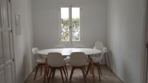 un comedor blanco con una mesa y sillas blancas en Grupoandria Villa Dora, en Cala en Blanes
