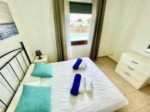 sypialnia z białym łóżkiem z niebieskimi poduszkami w obiekcie Villa 1B w mieście Playa Blanca +14 zdjęć