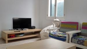 sala de estar con TV y 2 sillas en Grupoandria Villa Dora, en Cala en Blanes