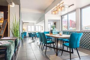 a dining room with a table and blue chairs at Contact Hôtels Les Pierres Dorées in Ambérieux d'Azergues