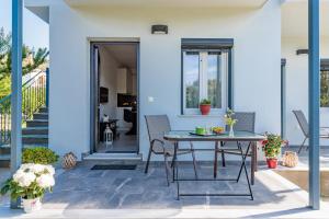 a patio with a table and chairs on a house at The Green Yard Apartment in Skopelos Town +17 photos