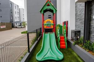 um parque infantil num edifício com escorrega em City Slick at 92 on Stylish Apartment in Carlswald em Midrand