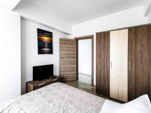 Schlafzimmer mit einem Bett und einem Flachbild-TV in der Unterkunft Aqua Vista NUBA - Vedere Top la Mare si Lac - Summerland in Mamaia