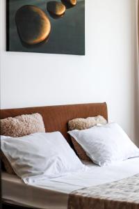 ein Bett mit zwei weißen Kissen und einem Bild an der Wand in der Unterkunft Aqua Vista NUBA - Vedere Top la Mare si Lac - Summerland in Mamaia