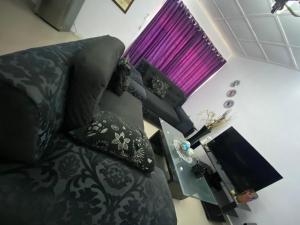 a living room with a black couch and a table at Harmonious haven services in Ibadan